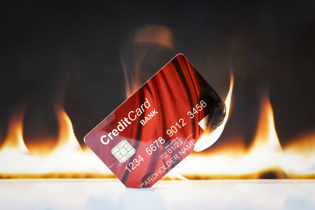 Bank credit card in flames on black background. 