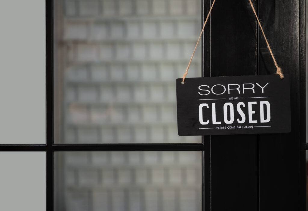 Signboard of "sorry we are closed please come back again" hanging on door front.