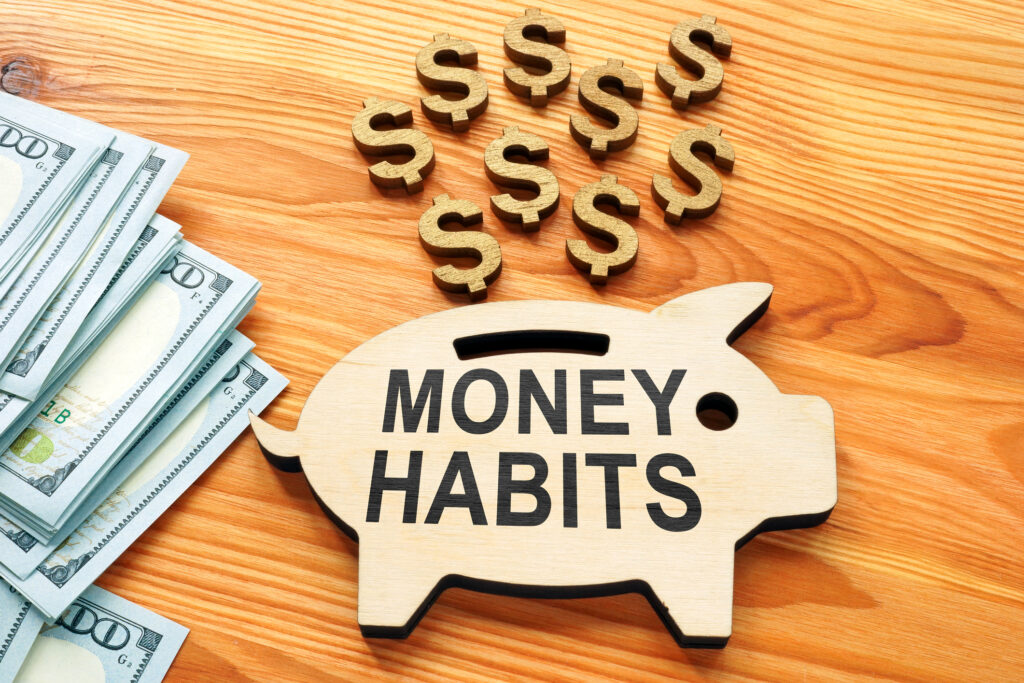 Money habits sign on the wooden piggy bank.