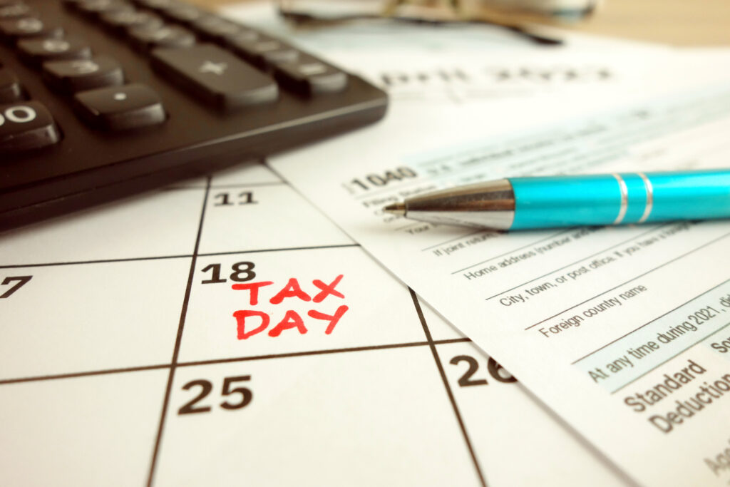 Tax payment day marked on a calendar - April 18 with 1040 form, financial concept