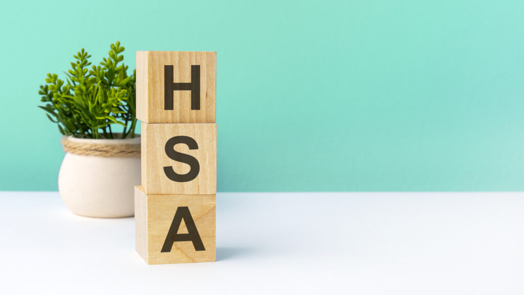 word from wooden blocks with letters. business concept on green background. copy space available. hsa - short for Health Savings Account