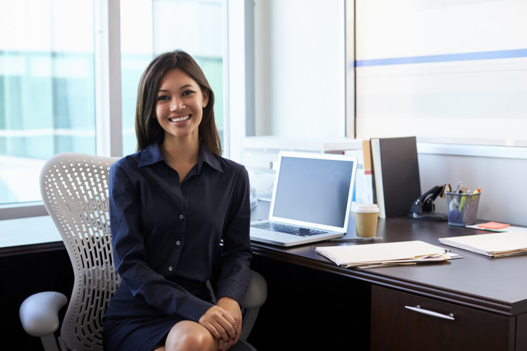 Portrait Of Female Financial Professional Sitting At Desk In Office