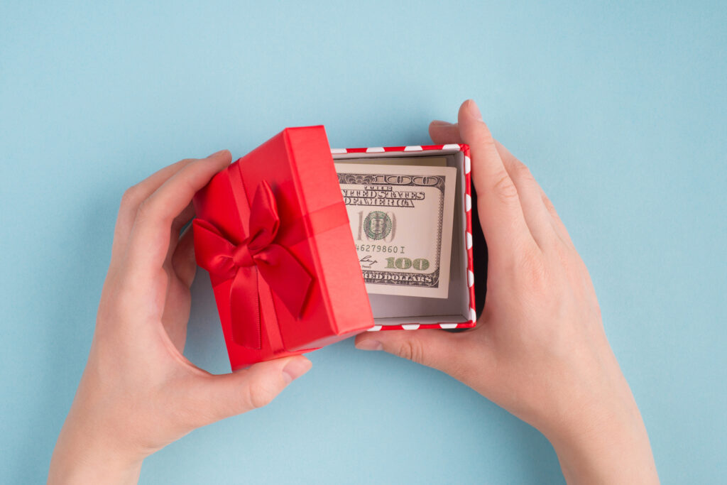 Top above overhead close up first person view photo of female hands open box with 100 american dollar bills. cashback.