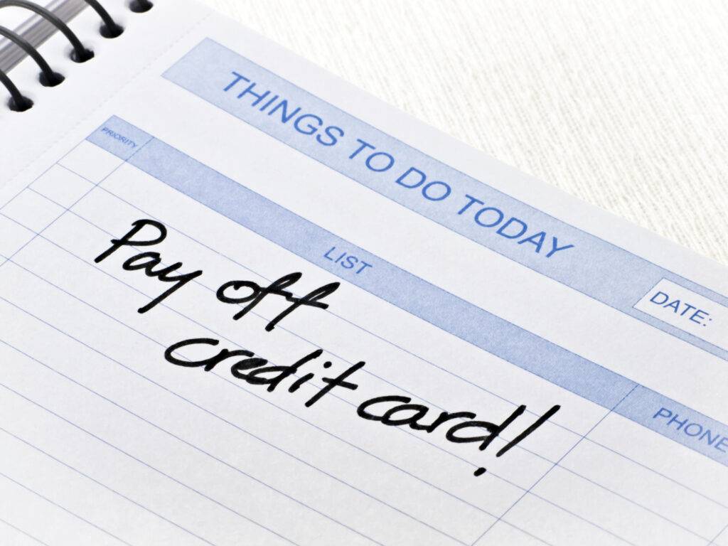 Things to do today notepad with pay off credit card! written in black pen.