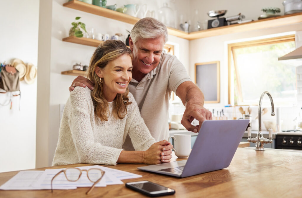 Happy pension couple with laptop and paperwork for retirement planning. Elderly, senior people for life insurance