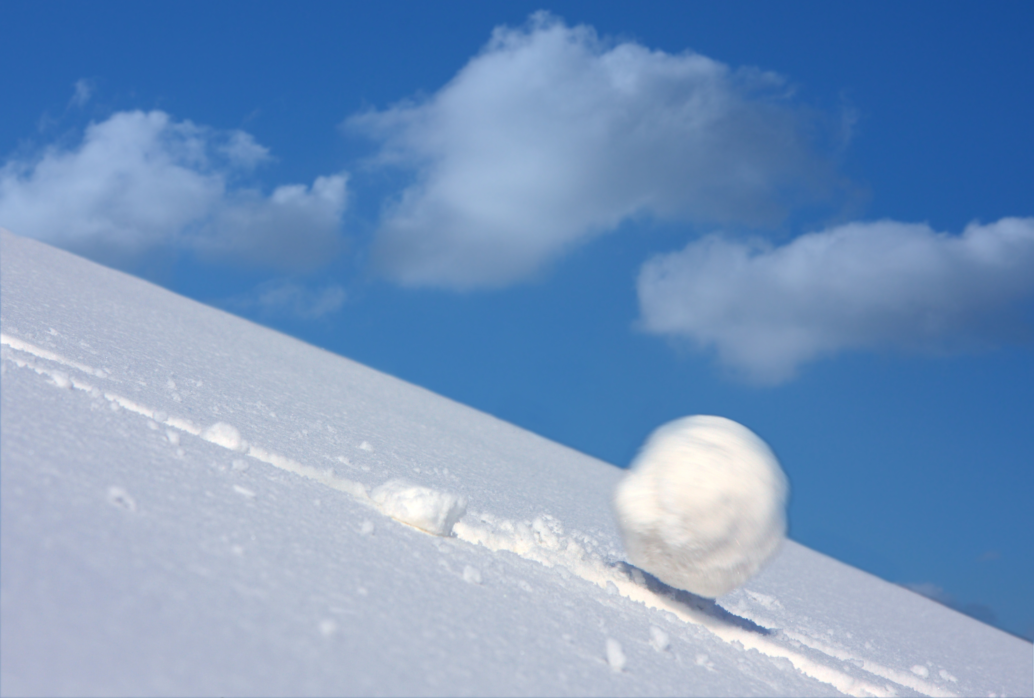 Snow ball slides downhill and speeds up.