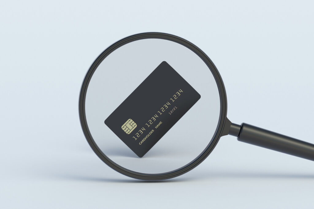 Credit card behind magnifying glass. 